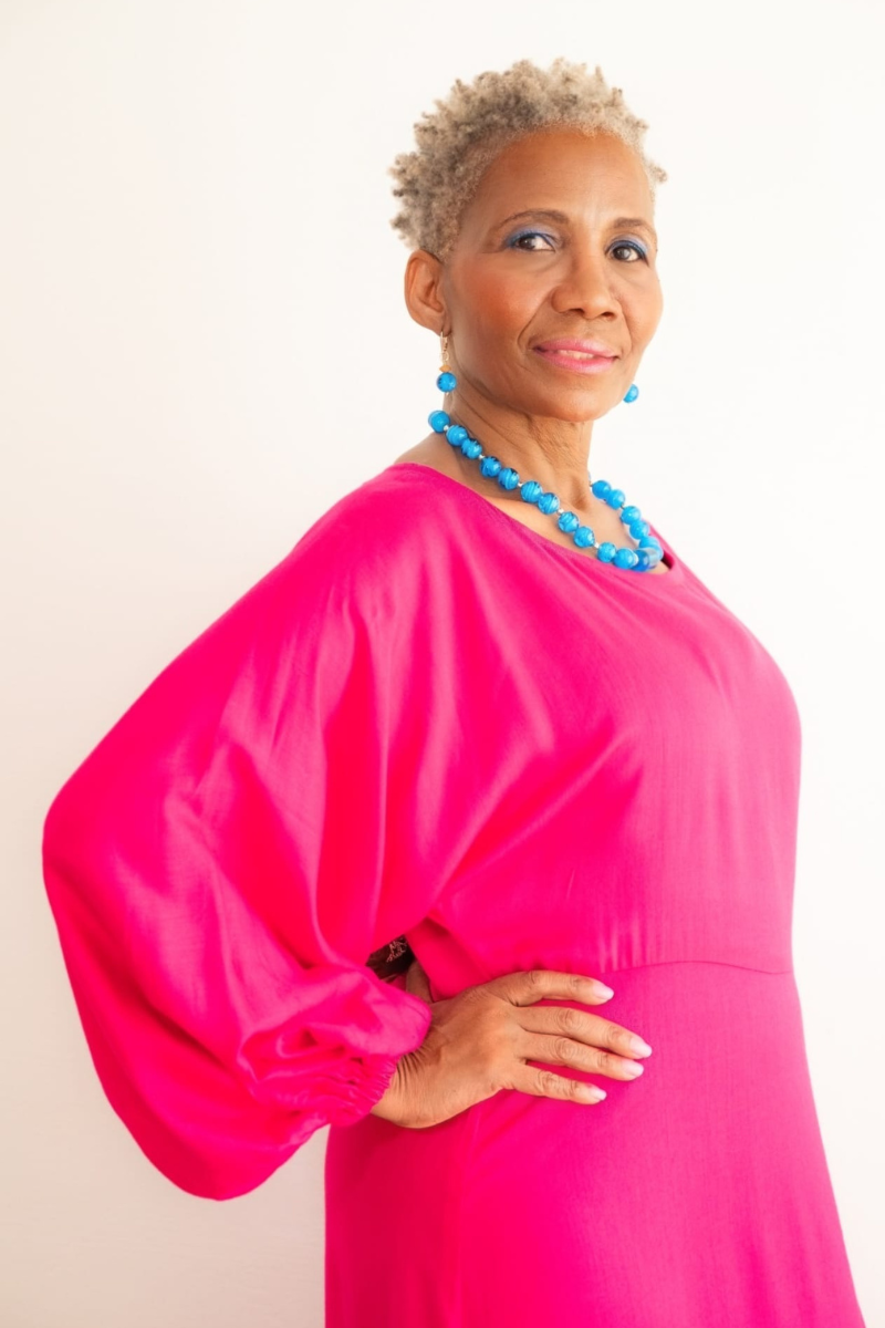 Lordana model is wearing a bright pink dress with blue beads matching earrings